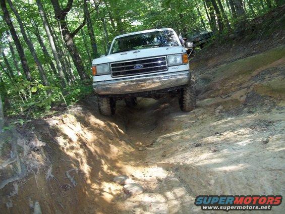 White 1990 Ford Bronco navigating a steep dirt trail