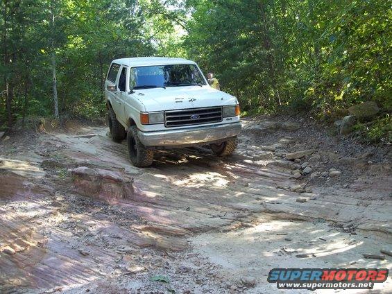 White 1990 Ford Bronco on a rocky off-road trail