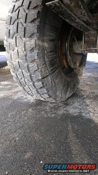 Close-up of a worn tire and visible suspension parts