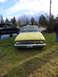 1961 Ford Ranchero - A yellow coupe utility, likely a 1960 model, is parked on grass with a black pickup truck nearby.
