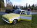 1961 Ford Ranchero - A two-tone Ford Falcon is parked on a grassy area beside a black pickup truck.
