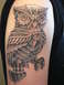 1972 Ford Pinto - A detailed steampunk owl tattoo covers the upper arm, intricate mechanical elements.