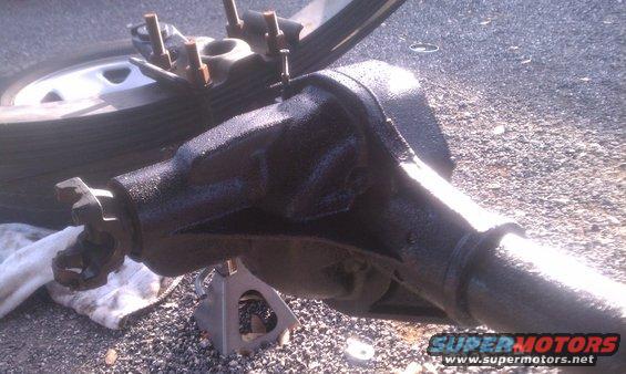 Rear axle assembly on jack stands, with leaf spring and tire visible