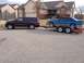 2012 Dodge Durango - A 2012 Dodge Durango is seen towing a blue coupe on a U-Haul trailer in a residential area.