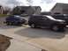 2012 Dodge Durango - A dark red Dodge Durango tows a blue Ford Mustang on a trailer in a suburban driveway.