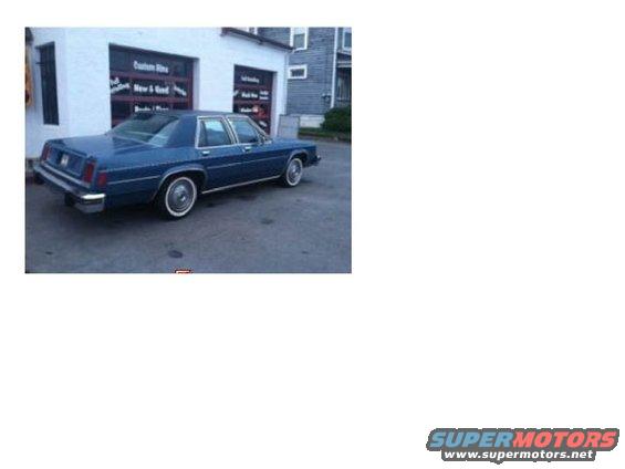 Blue sedan parked in front of a building with garage doors