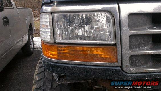 1995 Ford Bronco front corner with grille and headlight, next to another truck