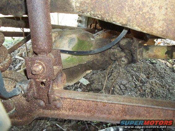 Undercarriage view of rusty shock absorber and differential assembly