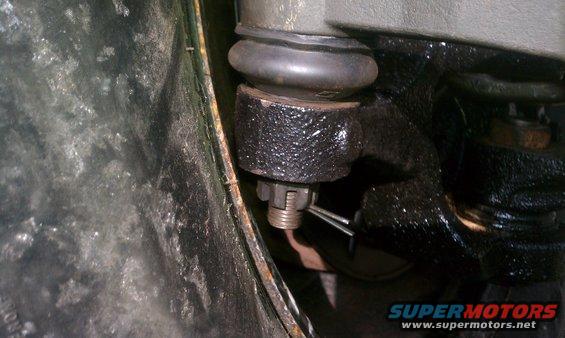 Close-up of a ball joint assembly with a cotter pin and castle nut