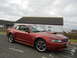 2003 Mercury Marauder - Red coupe with hood scoop parked on a street with a building in the background.