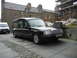 2003 Mercury Marauder - Hearse parked on a street with a white van nearby. Construction scaffolding is visible.