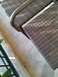 1960 Ford Falcon - Close-up of outdoor wicker furniture on a tiled patio, with a metal railing in the foreground.