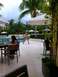 1960 Ford Falcon - A resort scene with people relaxing by the pool and under umbrellas, with palm trees in the background.