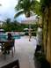 1960 Ford Falcon - A resort scene with palm trees, lounge chairs, and people enjoying the poolside area.