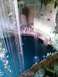 1960 Ford Falcon - A natural sinkhole in the Yucatan Peninsula, Mexico, with people observing the clear blue water from the edge.