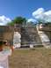1960 Ford Falcon - A person photographs ancient stone ruins, possibly Chichen Itza, on a sunny day.