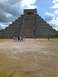 1960 Ford Falcon - Tourists gather in front of the ancient El Castillo pyramid under a cloudy sky.