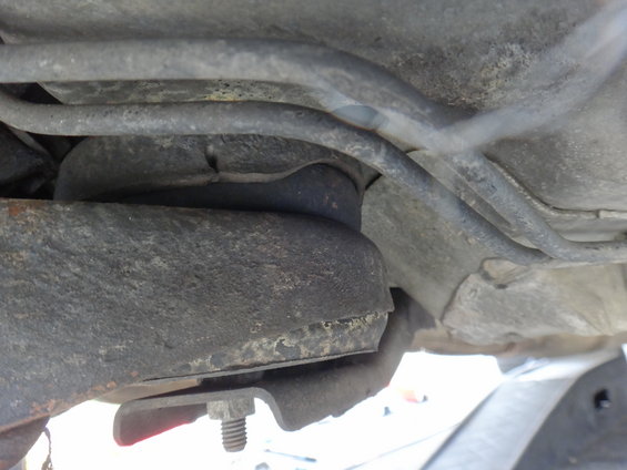 Close-up of a worn suspension bushing with metal bracket and bolt