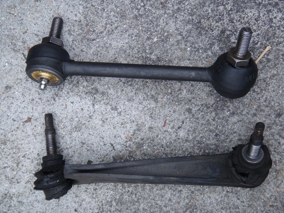 Two car suspension stabilizer links, one appears new, the other worn