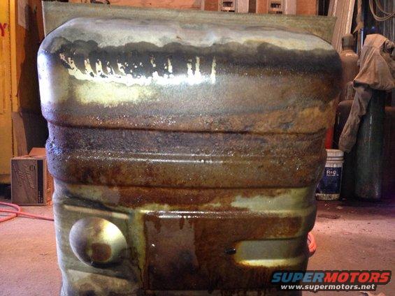 Heavily rusted fuel tank with visible liquid drips and grime