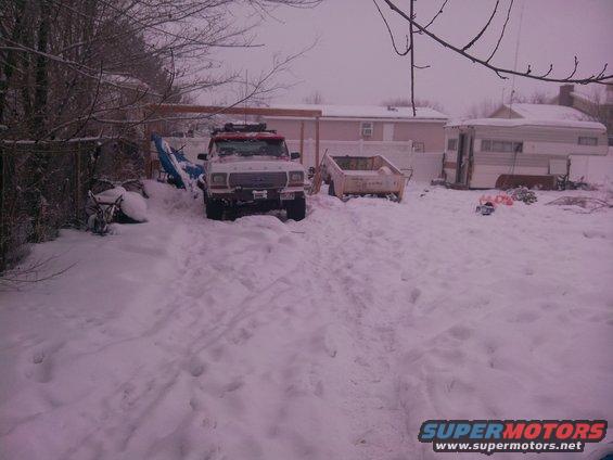 1979 Ford Bronco in snow, front view, white with red trim, roof rack, some snow on windshield