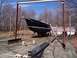 1989 Ford Bronco - A black sailboat named Faith is positioned on a dry dock with a large metal structure overhead.