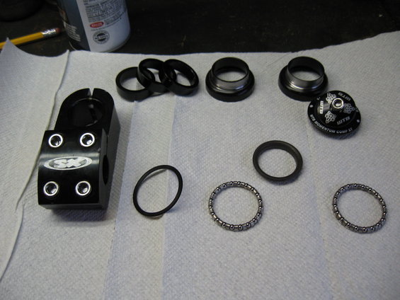 Black bicycle stem and headset components laid out on a white cloth