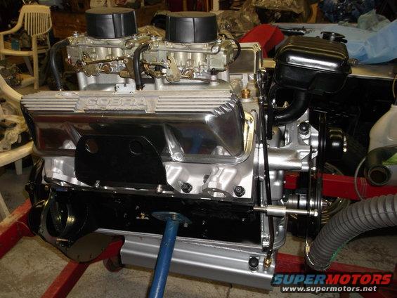 V8 engine with dual carburetors and 'COBRA' valve covers, mounted on an engine stand