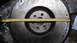 1977 Ford F-150 - A metal flywheel is measured with a tape measure, indicating its size.