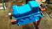 1977 Ford F-150 - Engine oil pan painted bright blue, mounted on an engine stand.