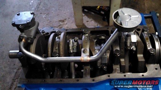 Engine block with crankshaft, oil pump, and pickup tube. Blue painted block, metal components