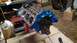 1977 Ford F-150 - A V8 engine block, painted blue, sits on a stand in a workshop setting.