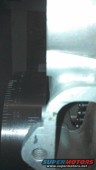 Close-up of engine timing chain and gear with a measurement scale