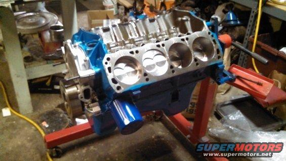 V8 engine block with pistons visible, mounted on an engine stand