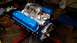 1977 Ford F-150 - A Ford V8 engine with blue valve covers is displayed on a red engine stand.