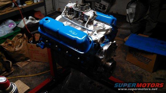 Ford V8 engine with blue valve covers on a red engine stand