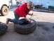 1987 Ford Ranger - A person kneels to work on a tire, with the front portion of a white truck visible to the left.