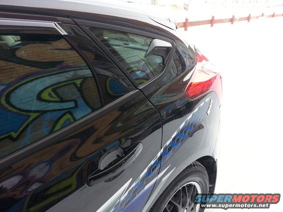 2012 Ford Focus rear side view, black paint with graffiti reflected in window