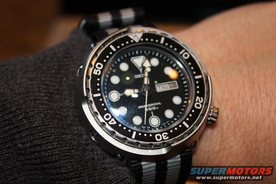 Watch on wrist, black dial, silver bezel, NATO strap. Shows 'SEIKO PROFESSIONAL 300m' and day/date