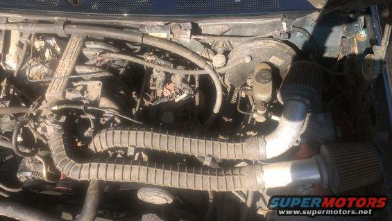 Engine bay showing intake manifold, brake booster, and aftermarket air filters