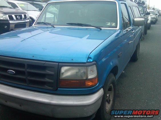 Blue Ford F-Series truck, front quarter view, showing a dark grille with a Ford emblem and a silver bumper