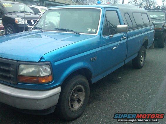 Blue 1993 Ford F-150 pickup truck, 3q-front view, with camper shell