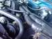 1993 Ford Bronco - The engine bay of a 1993 Ford Bronco is visible, various components and blue exterior paint.