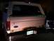 1994 Ford Bronco - The rear of a white SUV, possibly a Ford Bronco, shows significant rust around the tailgate and bumper.
