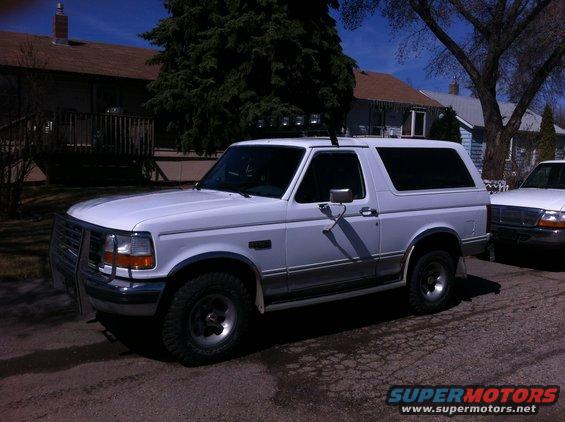 1994 Ford Bronco parked on a street with another vehicle to its right