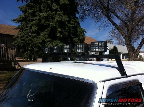 Roof-mounted light bar with four square lights on a white vehicle