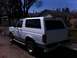 1994 Ford Bronco - This white Ford Bronco is parked on a residential street under a clear blue sky.