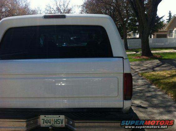1994 Ford Bronco rear with a white camper shell and Saskatchewan license plate 744 HSV