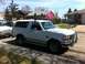 1994 Ford Bronco - A white Ford Bronco is parked on the side of the road in front of houses.