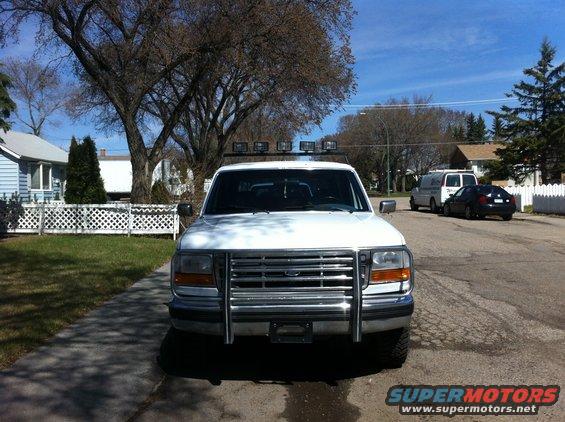 White 1994 Ford Bronco front view with chrome grille guard and roof lights